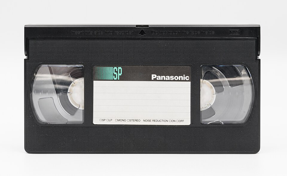 Чорна відеокасета VHS з прозорим віконцем і двома котушками